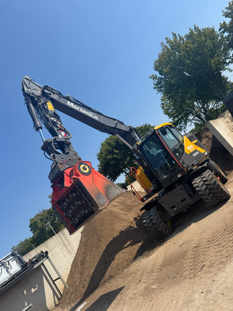 Mobilbagger mit Sieblöffel auf einer Gewerbebaustelle